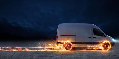 Picture of a van moving along with flames coming from the wheels