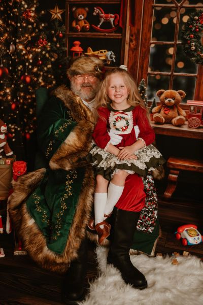 Santa Claus with a happy little girl in festive holiday setting.