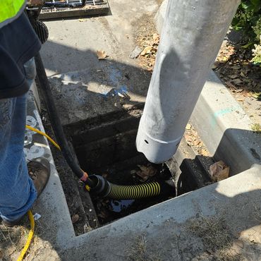 Using jet-vac to remove debris from storm drain system.