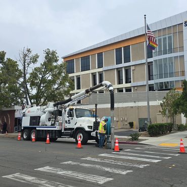 Worker using jet-vac truck to clean sewer.