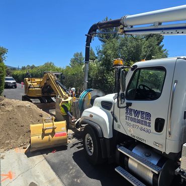 Jet-vac truck and excavator on a jobsite.