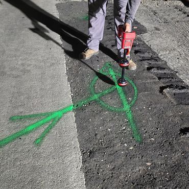 Worker locating a pipeline underground while mark-out service is being performed.