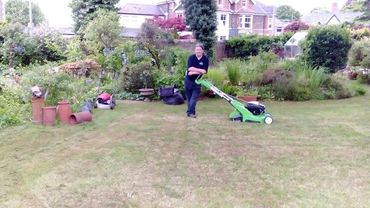 Image of our gardener busy mowing 
