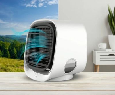 Compact white air cooler on a table with airflow visualization.
