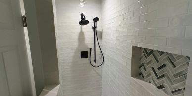 Modern shower with black fixtures and patterned tiles.