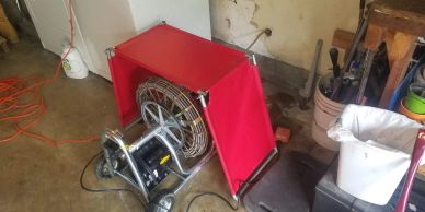 Drain cleaning machine in a garage.