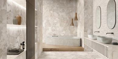 Elegant beige bathroom with a modern bathtub and double sinks.