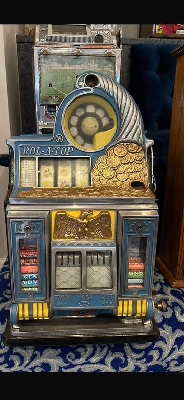 Vintage Rol-A-Top slot machine with intricate design and gold coin details.