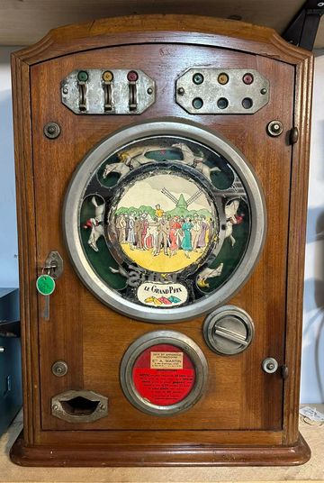 Vintage wooden arcade machine with a colorful racing scene and coin slot.