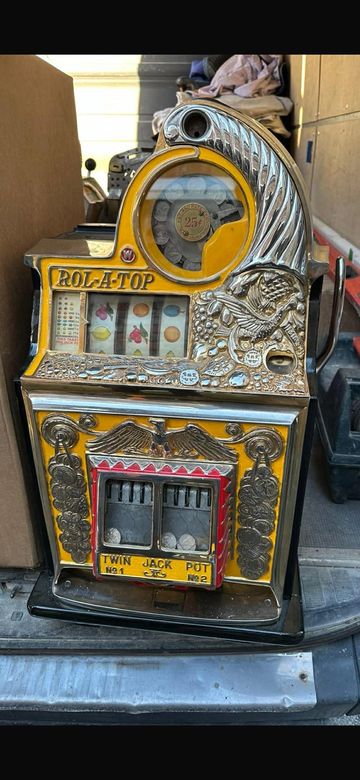 Vintage Rola-Top slot machine with intricate designs and coin mechanism.