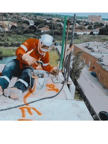 Worker in safety gear on a rooftop with tools.