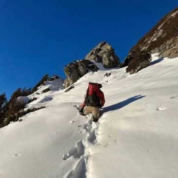 Person hiking up snowy mountain slope.