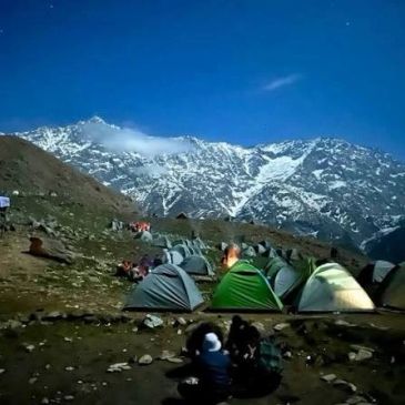 Night camping at the base of snowy mountains.