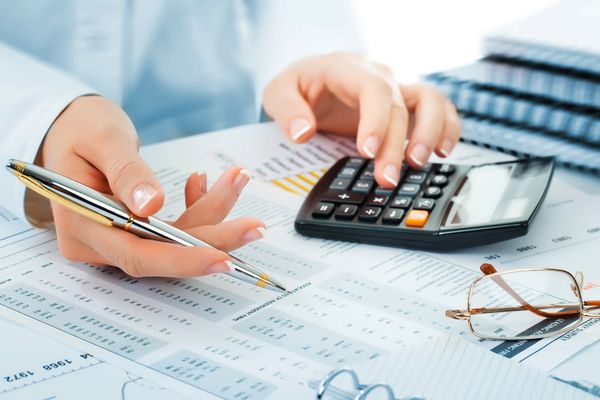Accountant using calculator and pen