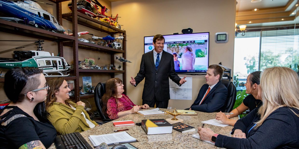 Group of people sitting around a table as Keith Dorson, Business Coach, leads the meeting.