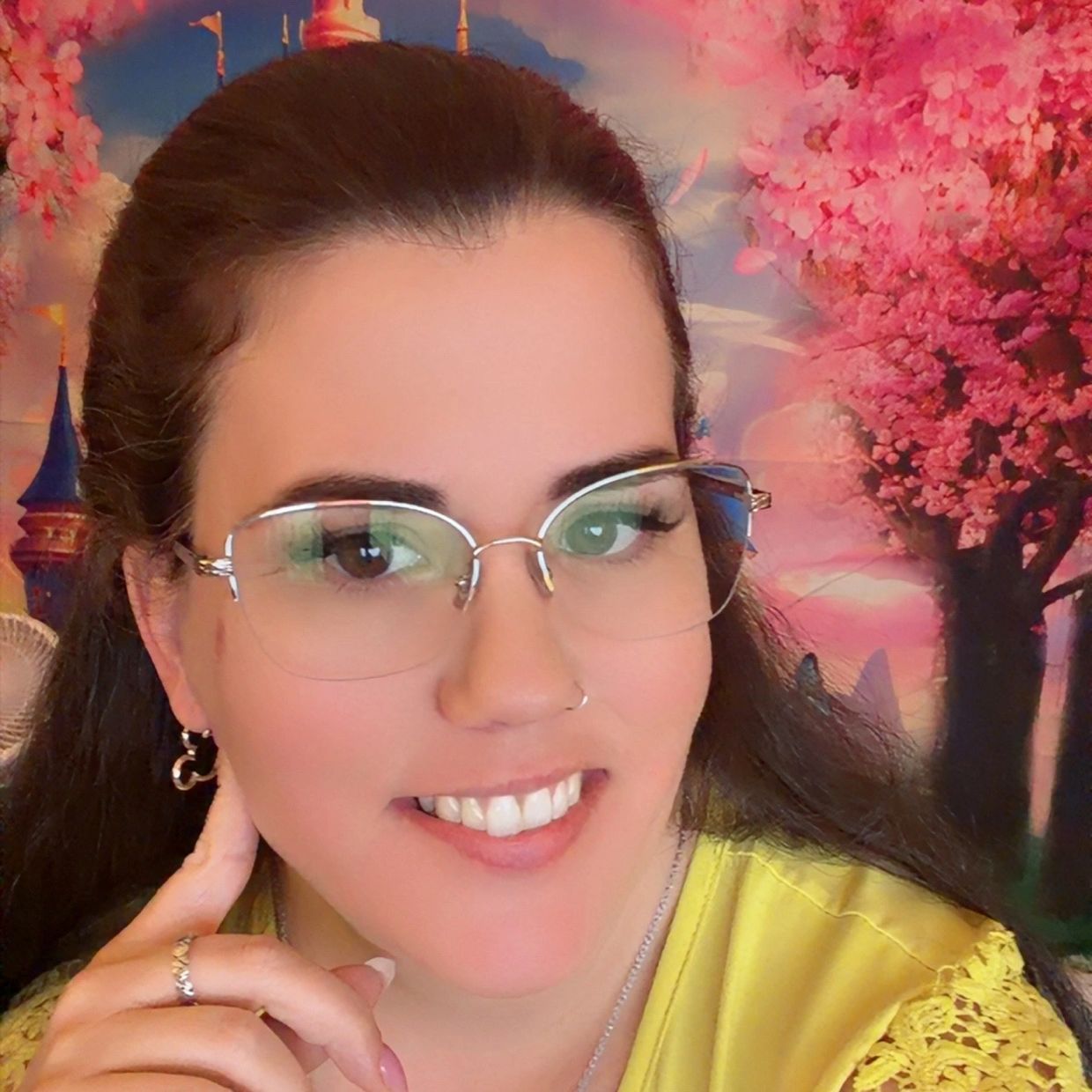 Woman with glasses smiling in front of a colorful fantasy castle backdrop.