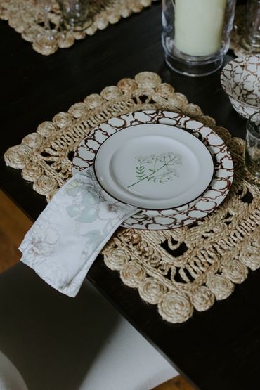 Elegant table setting with floral plates and woven placemats.