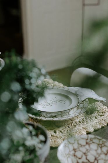 Elegant floral-patterned dinnerware set on a textured placemat.