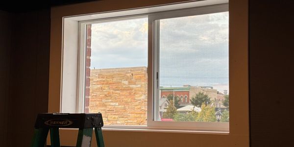 View through a window showing buildings and sky.