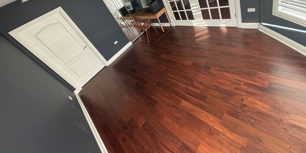 Room with polished wooden floor and dark walls.