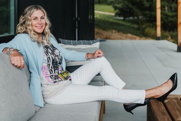 Woman relaxing on a couch outdoors, smiling.