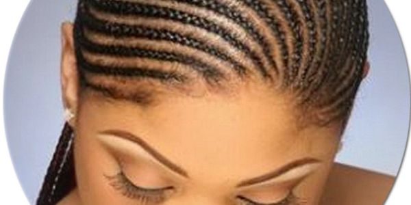 Close-up of woman with detailed cornrow hairstyle.