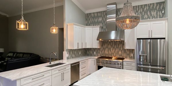 Custom kitchen remodel in Westwood Lakes with Pompeii quartz, shaker cabinets & decorative lighting.