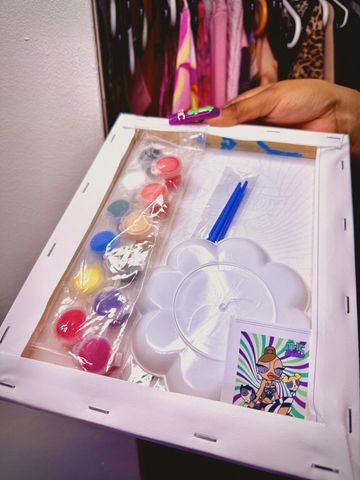 Painting kit with colors, brushes, and a canvas.