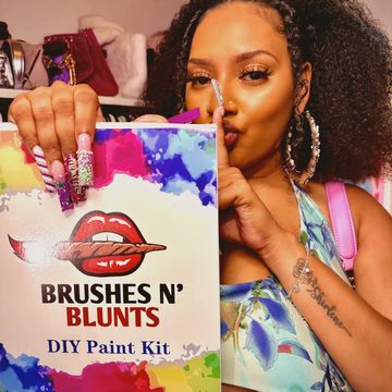 Woman holding a Brushes N' Blunts DIY Paint Kit.