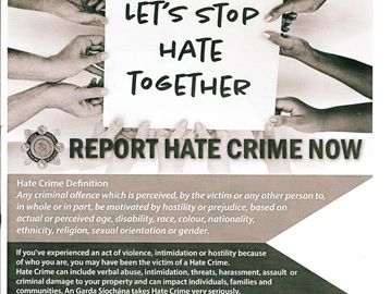 Hands hold a sign saying 'Let's stop hate together' urging to report hate crimes.
