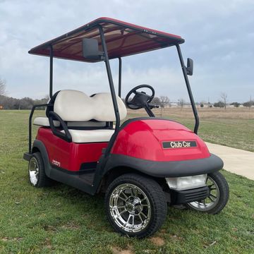 A red 2006 Club Car Precedent with 12in chrome wheels, white seats, and a rear flip seat.