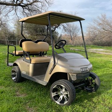 A Champaign 2017 EZGO TXT with 12in wheels and a rear flip seat.