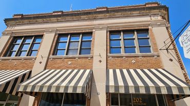 Historic building with striped awnings and a sign for The Holly Vault food and spirits.