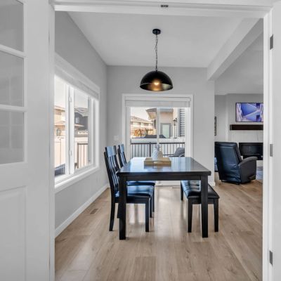 Minimalist dining area with black furniture and wooden floor.