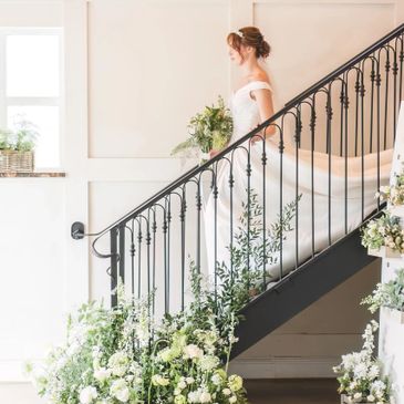 bride takes the stairway down post-ceremony! In a beautiful dress and charming flower display