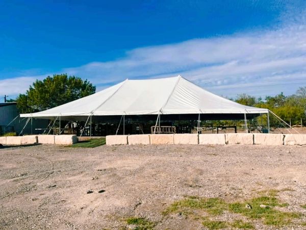 Large white event tent set up outdoors on a sunny day.