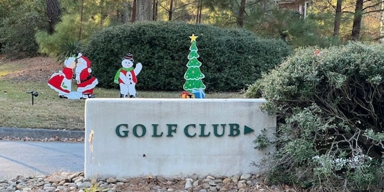 Golf club sign with festive holiday decorations including Santa, snowman, and Christmas tree.