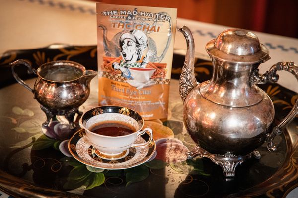 Silver tea pot and decorative tea cup with chai tea