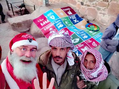 Young Arab pilgrims on Mount Sinai, Egypt, share 3 Finger Sustainability Symbol with SustainaClaus
