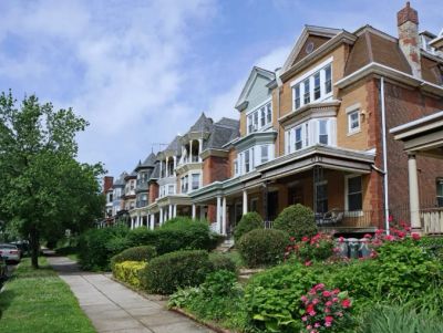 Row of victorian-style houses with gardens.
