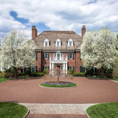 Big brick mansion with blossoming trees.