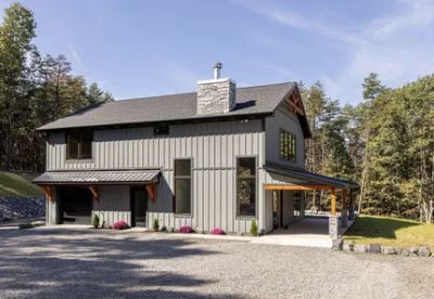 Modern two-story house with gray siding and wooden accents.