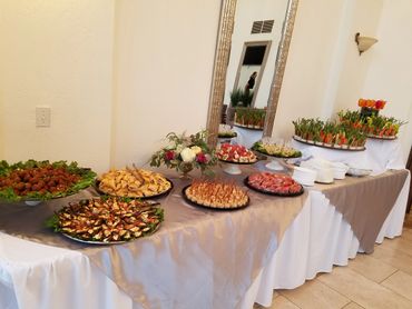 Elegant buffet table with a variety of appetizers and fresh vegetables.