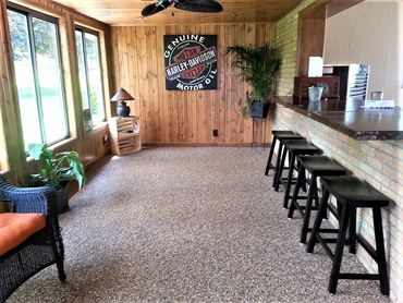 Pebblestone Floor in sunroom of with bar stools and Harley Davidson poster