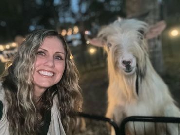 One of the dinner party guests posing for a photo with a happy goat.