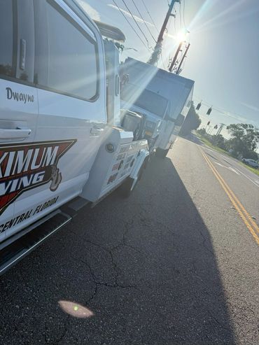 Medium-duty wrecker hauling Advent ambulance – towing service Central Florida | Maximum Towing