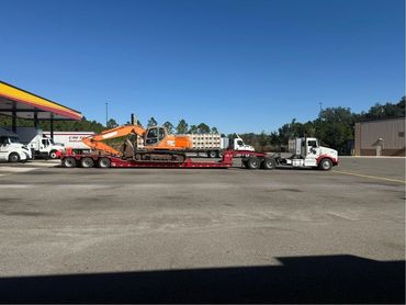 excavator on 50-ton lowboy trailer - heavy equipment towing in Central Florida | Maximum Towing