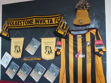 Folkestone Invicta FC team merchandise displayed on a wall