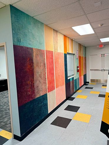Color-block textured wall mural along a commercial office hallway in Arizona