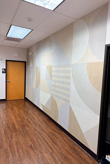 Neutral geometric wall mural in a commercial office hallway in Arizona
